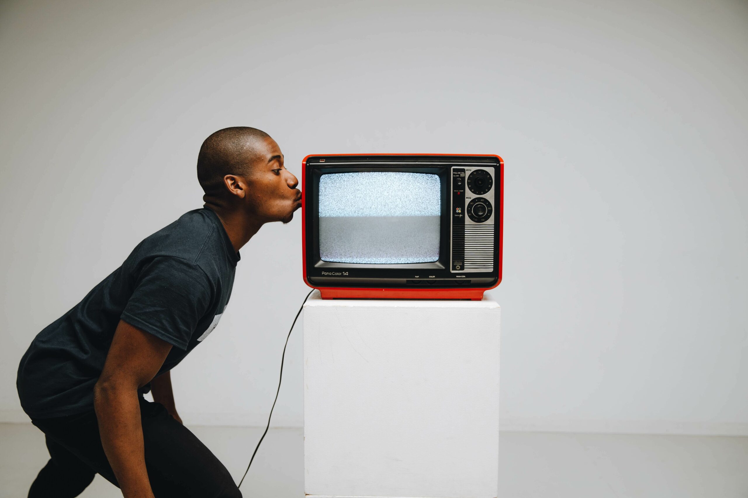 Hombre besando una televisión retro