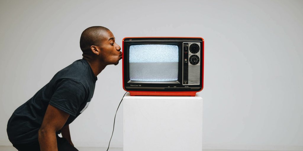 Hombre besando una televisión retro
